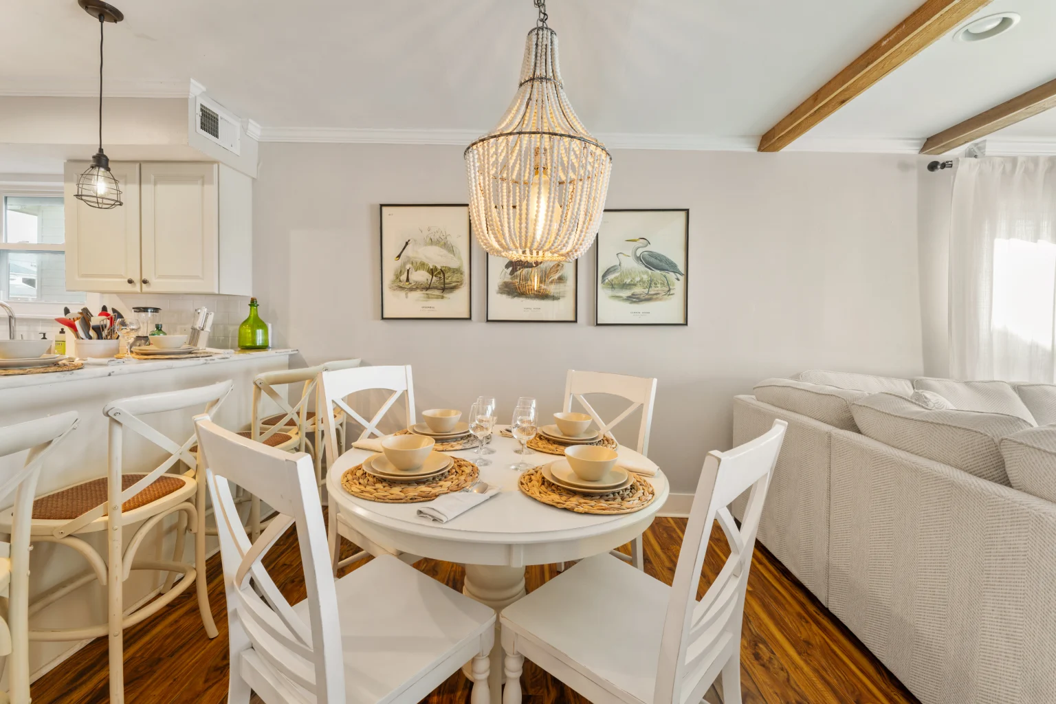 Round dining table under a beaded chandelier, SouthWind East
