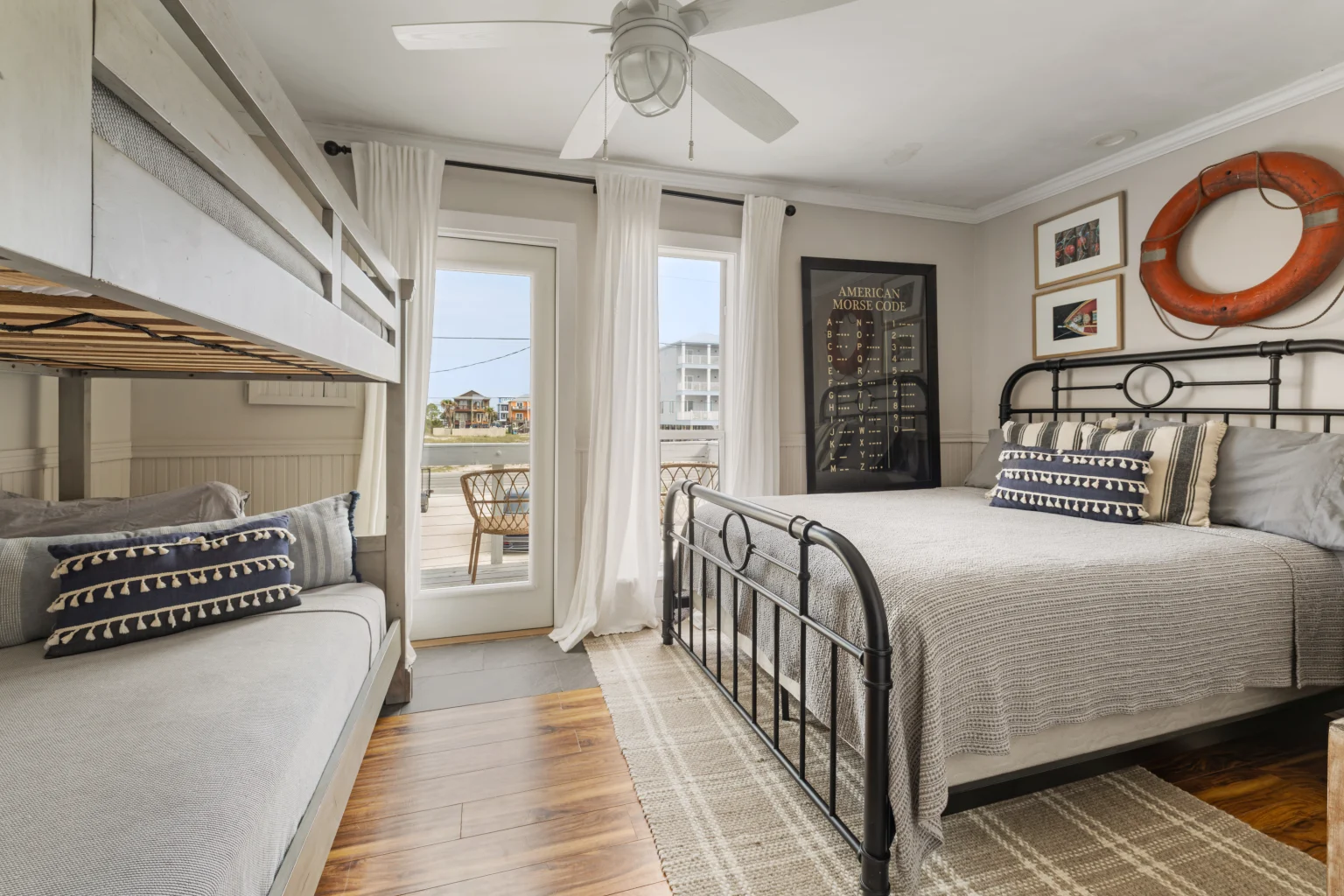 Bedroom with iron queen bed, bunks and balcony door, SouthWind East