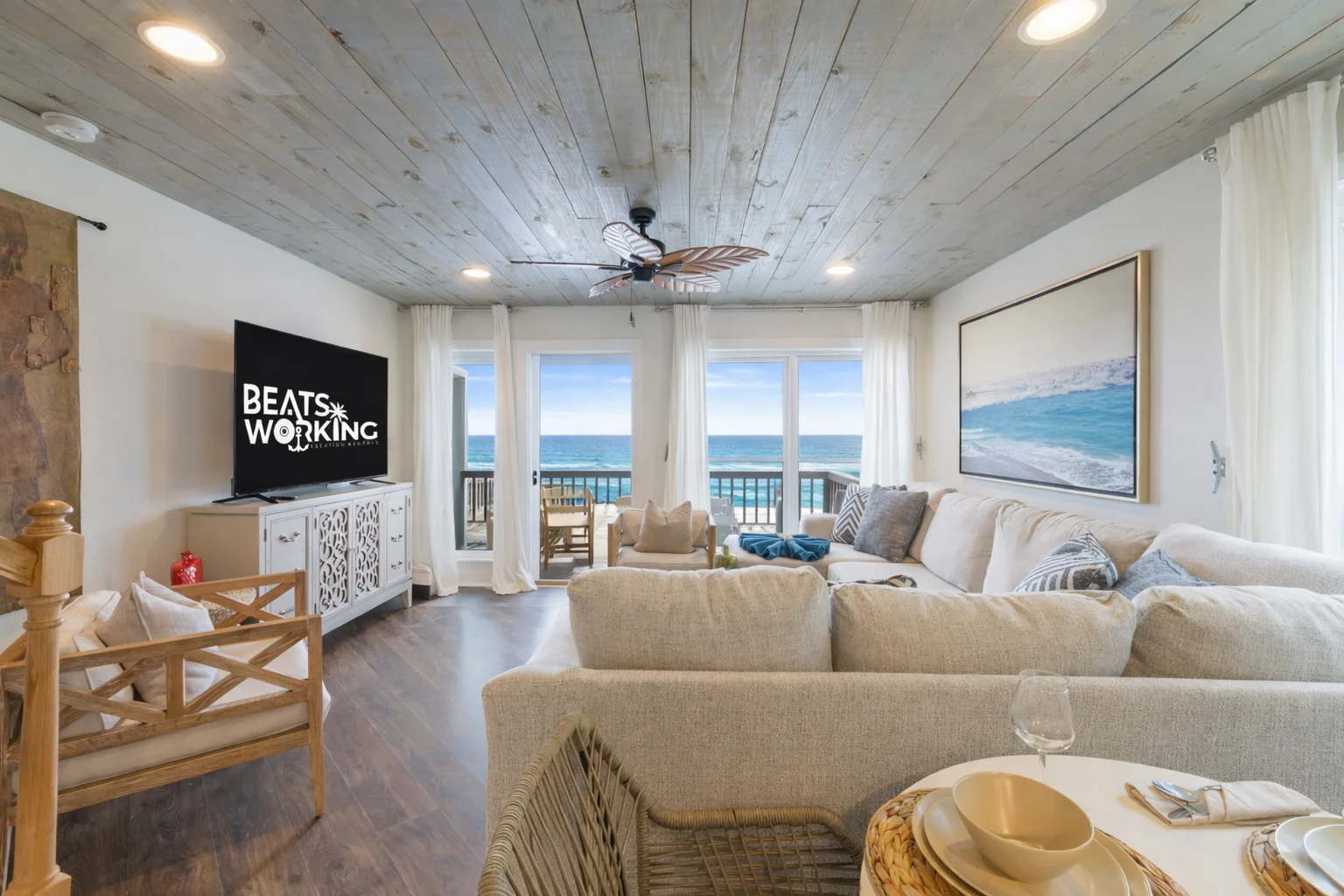 Living room with Gulf-view windows and wood-plank ceiling, SouthWind West