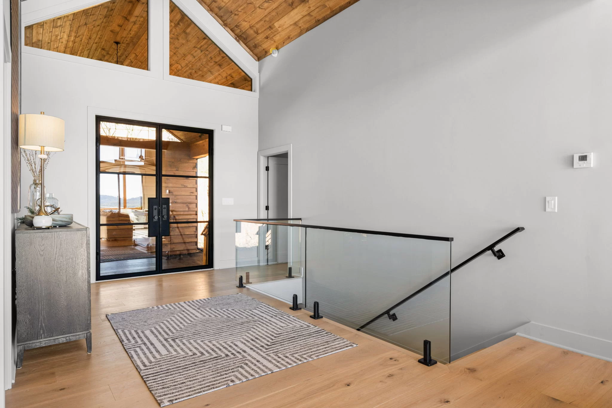 Entry hall with a glass stair rail and the front door, View Finder II