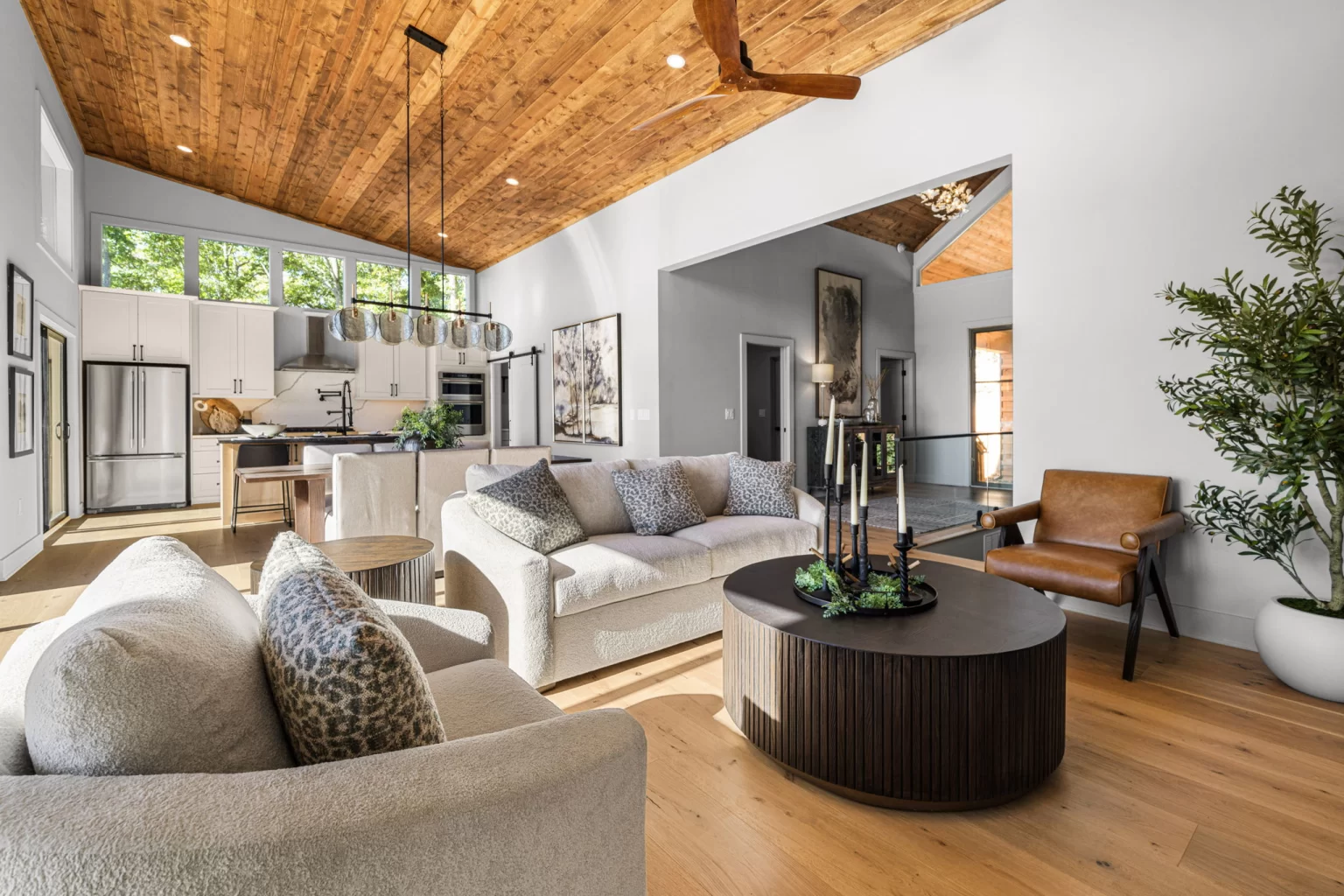 Living room with sofas and a round coffee table, kitchen beyond, View Finder II